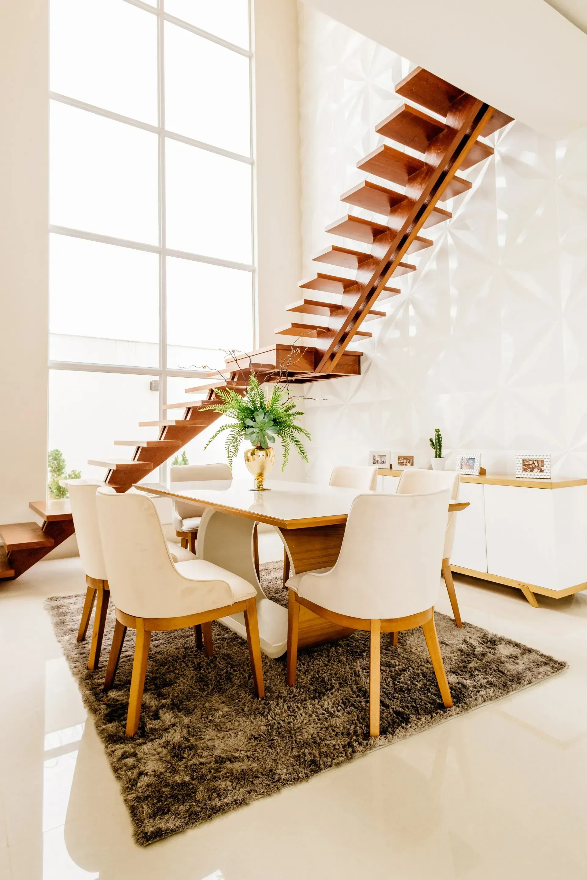 Airy dining room with a wooden staircase